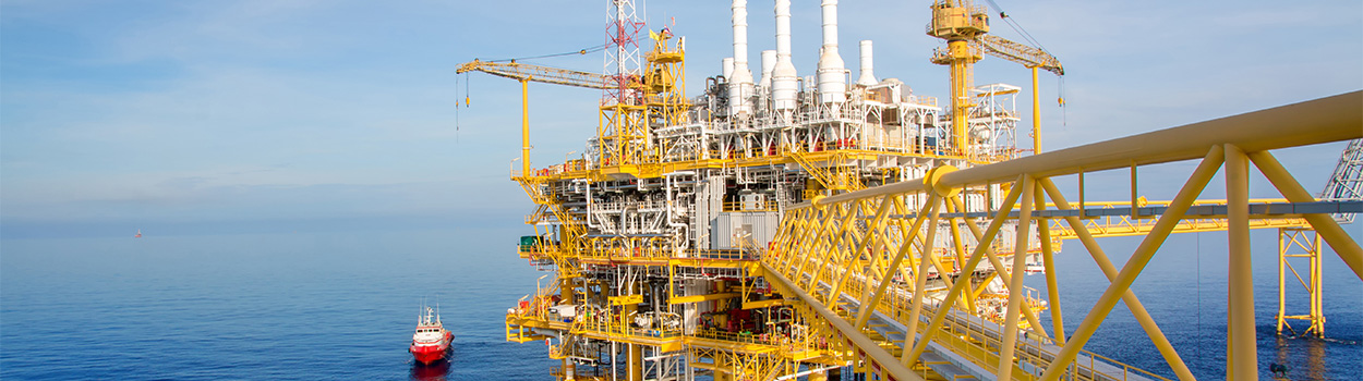 oil drilling platform in ocean with supply boat and clear sky highlighting twelve operational units