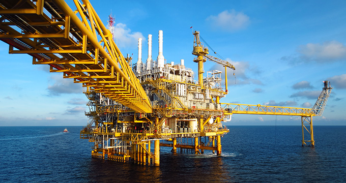 an offshore oil rig with yellow structures and a blue sky background showcasing energy production and industrial engineering