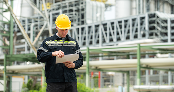construction worker reviewing plans at industrial site focusing on project management and safety standards 2 safety protocols 2 construction guidelines