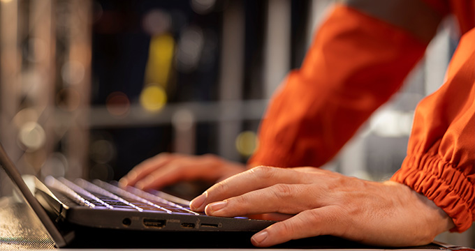 hands typing on a laptop keyboard in a workspace with a focus on technology and productivity